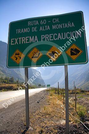 Spanish language road sign warning of hazardous road conditions at the foot of the Andes Mountain Range in Chile.