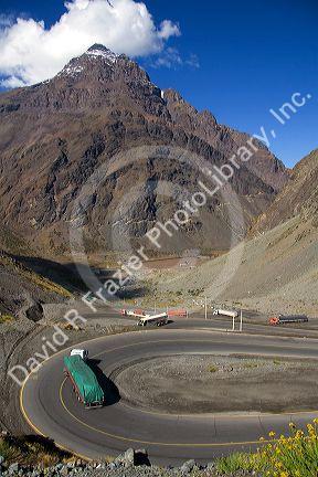 Trucks drive on switchback roads in the Andes Mountain Range in Chile.