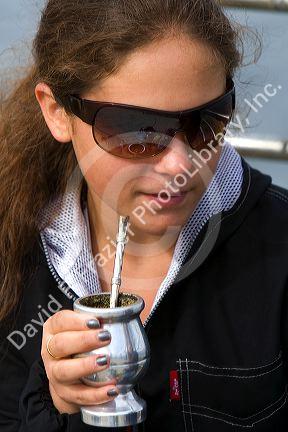 Girl drinking mate at Ushuaia on the island of Tierra del Fuego, Argentina.