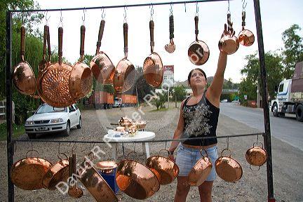 Roadside vendor selling copper pots and pans in rural Chile.