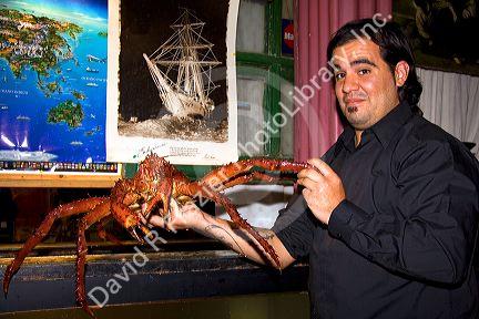 Waiter holding a king crab at a seafood restaurant at Ushuaia, Argentina.