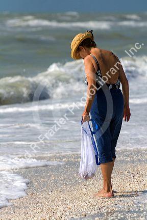 Beachcomber searching for seashells on the beach at Sanibel Island on the Gulf Coast of Florida.