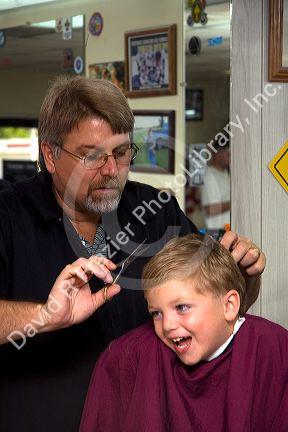 Barber giving a three year old boy a haircut in Tampa, Florida. MR