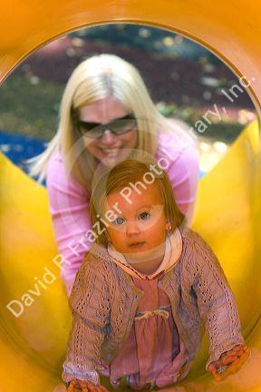32 year old mother helping her 15 month old daughter down a slide in Tampa, Florida. MR