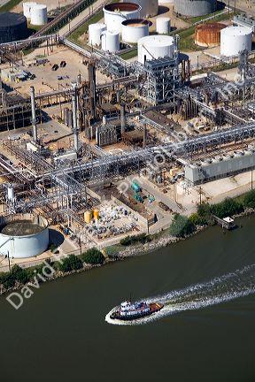 Aerial view of a tugboat on the Houston Ship Channel passing an oil refinery in Houston, Texas.