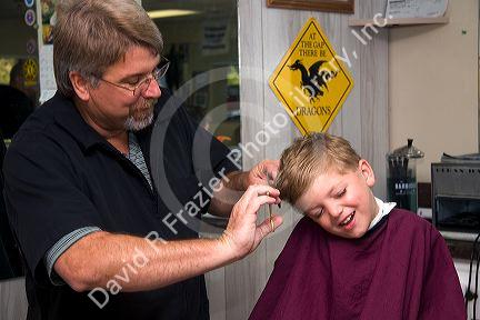 Barber giving a three year old boy a haircut in Tampa, Florida. MR