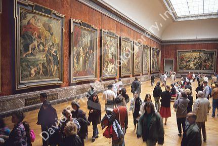Visitors view paintings at The Louvre in Paris, France.