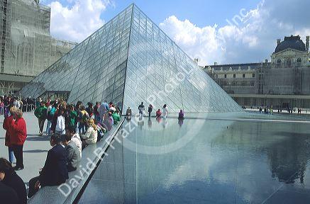 Visitors in front of the glass pyramid at the entrance to the Louvre in Paris, France.