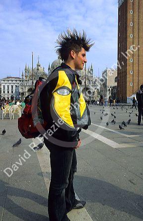 Young Italian man with mohawk hairstyle in the Piazza San Marco at Venice, Italy.