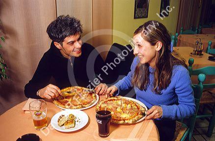 Young couple dines on pizza in a restaurant at Sirmione, a comune in the province of Brescia, Lombardy, Italy.