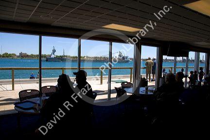 Visitors look at out the windows of the Vantage Point Great Lakes Maritime Center located on the St. Clair River where it meets the Black River at Port Huron, Michigan.