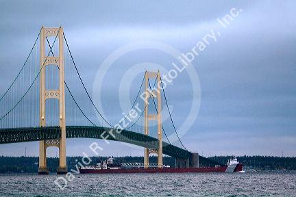 A barge passing under the Mackinac Bridge in the Straits of Mackinac at Mackinaw City, Michigan.