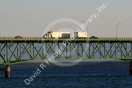 Trucks and autos travel over the Mackinac Bridge spanning the Straits of Mackinac at Mackinaw City, Michigan.