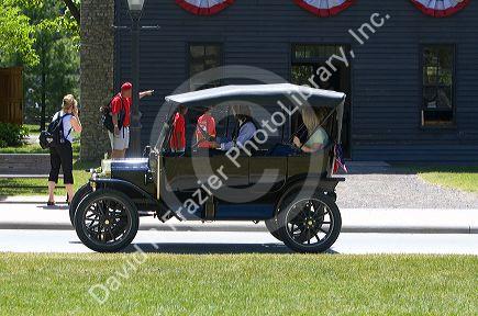 Visitors ride in a Ford Model T in Greenfield Village at The Henry Ford in Dearborn, Michigan.