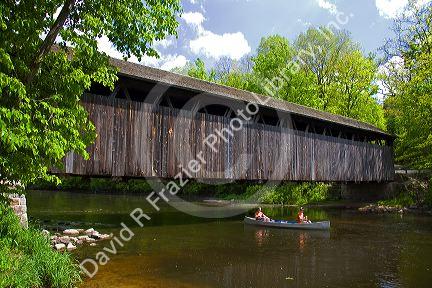 Canoe passing under the Whites Bridge on the Flat River in Keene Township, Michigan.