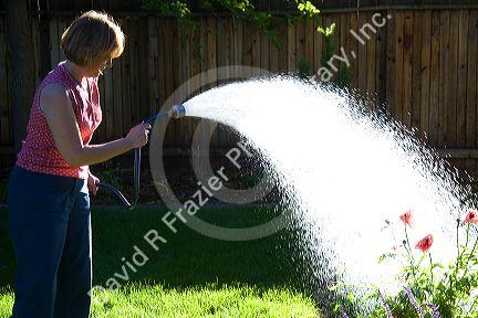 Woman watering flowers in Boise, Idaho. MR