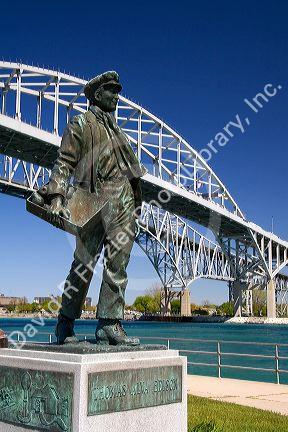 A statue of Thomas Edison by local artist Mino Duffy sits below the Blue Water Bridge along the St. Clair River at Port Huron, Michigan.