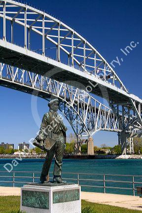 A statue of Thomas Edison by local artist Mino Duffy sits below the Blue Water Bridge along the St. Clair River at Port Huron, Michigan.