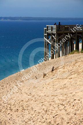 People stand on a viewing platform on the banks of Lake Michigan in Sleeping Bear Dunes National Lakeshore located along the northwest coast of the Lower Peninsula of Michigan.
