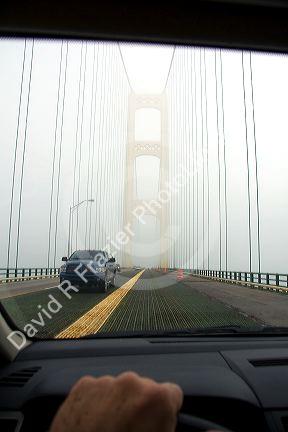 View from the inside of a car crossing the Mackinac Bridge on a foggy day in Michigan.