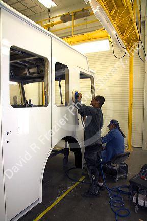 Worker using a power sander at Spartan Motors, a truck chassis manufacturer in Charlotte, Michigan.