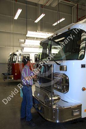 Worker cleaning a newly manufactured fire truck chassis at Spartan Motors in Charlotte, Michigan.