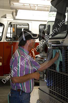 Worker cleaning a newly manufactured fire truck chassis at Spartan Motors in Charlotte, Michigan.