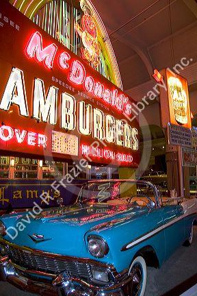 1956 Chevy convertable sits below a neon illuminated McDonald's sign in The Henry Ford Museum at Dearborn, Michigan.
