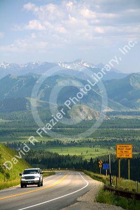 A vehicle travels over the high mountain Teton Pass on Wyoming Highway 22 near the state border of Wyoming and Idaho.