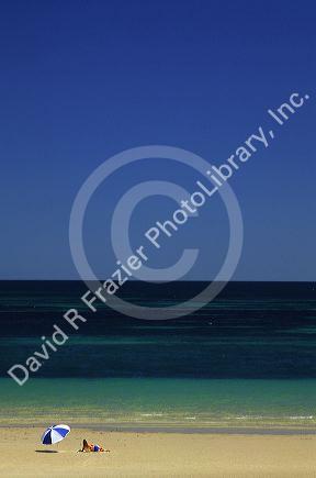 Beach scene with woman and umbrella near Adelaide, Australia.