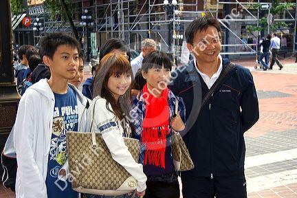 Asian family having their photo taken in the Gastown district of Vancouver, British Columbia, Canada.
