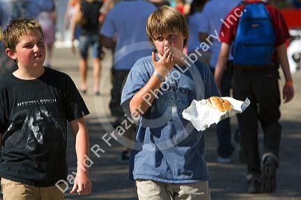 Boy eating fair food at the Western Idaho Fair in Boise, Idaho.
