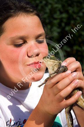 11 year old girl kissing a bullfrog in Boise, Idaho. MR