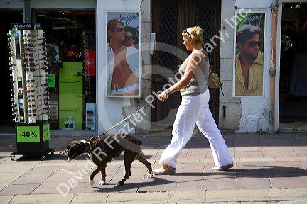 Woman walking a dog in the town of Saint-Jean-de-Luz, Pyrenees-Atlantiques, French Basque County, Southwest France.
