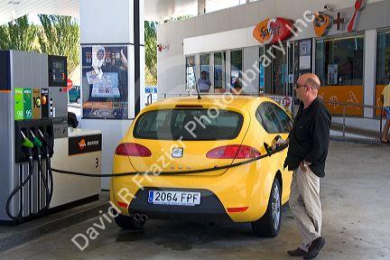 Customer filling his car with fuel at a gas station along the Autopista near Pamplona, Navarre, northern Spain.