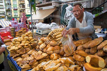 Vendor selling bread and baked goods at an outdoor market in the town of Cangas de Onis, Asturias, northern Spain.