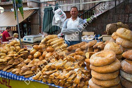 Vendor selling bread and baked goods at an outdoor market in the town of Cangas de Onis, Asturias, northern Spain.