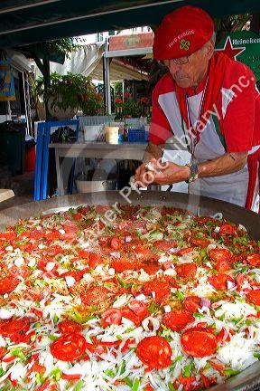 French Basque man cooking paella in the town of Biarritz, Pyrenees-Atlantiques, French Basque Country, Southwest France.