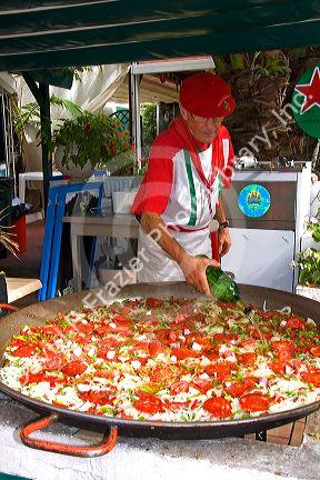 French Basque man cooking paella in the town of Biarritz, Pyrenees-Atlantiques, French Basque Country, Southwest France.