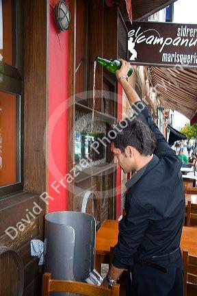 Server pouring cider at a cidereria in the town of Ribadesella, Asturias, northern Spain.
