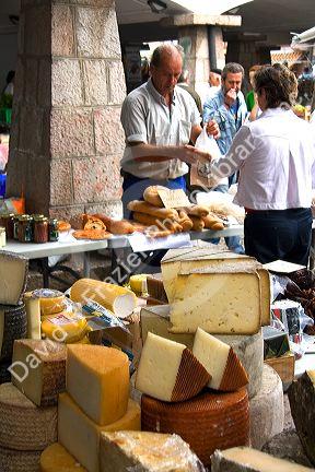 Vendors selling cheese and bread at an outdoor market in the town of Cangas de Onis, Asturias, northern Spain.