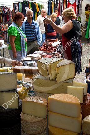 Vendor selling cheese and sausage at an outdoor market in the town of Cangas de Onis, Asturias, northern Spain.