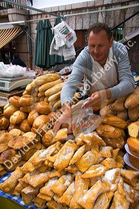 Vendor selling bread and baked goods at an outdoor market in the town of Cangas de Onis, Asturias, northern Spain.