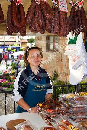 Spanish woman selling cured meats at an outdoor market in the town of Cangas de Onis, Asturias, northern Spain.