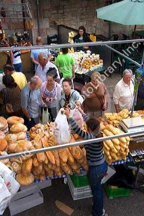 Customers purchasing bread at an outdoor market in the town of Cangas de Onis, Asturias, northern Spain.