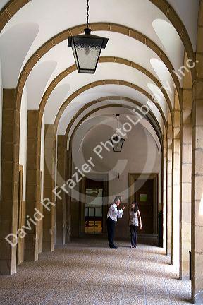 People stand under and arched portico on the campus of the University of Deusto in the city of Bilbao, Biscay, northern Spain.