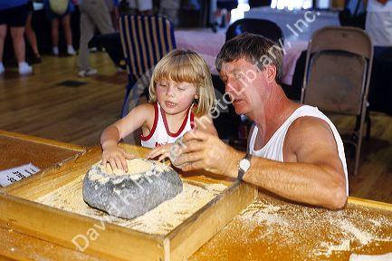 Father and daughter using a mortar and pestle in the Indian Museum of North America at the Crazy Horse Memorial in South Dakota.