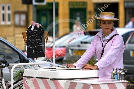 Female street vendor selling ice cream in the town of Moreton-in-Marsh, Gloucestershire, England.