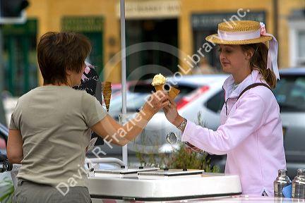 Female street vendor selling ice cream in the town of Moreton-in-Marsh, Gloucestershire, England.