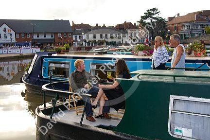 People socialize on boats in the River Avon at Stratford-upon-Avon, Warwickshire, England.